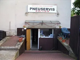 Vchod do prodejny pneuservisu s cedulí PNEUSERVIS